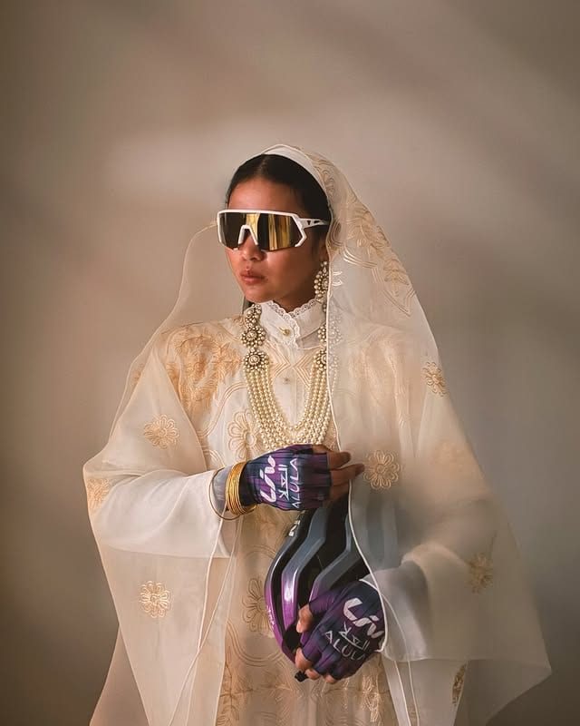 Moroj Adil in traditional Saudi dress holding her cycling helmet