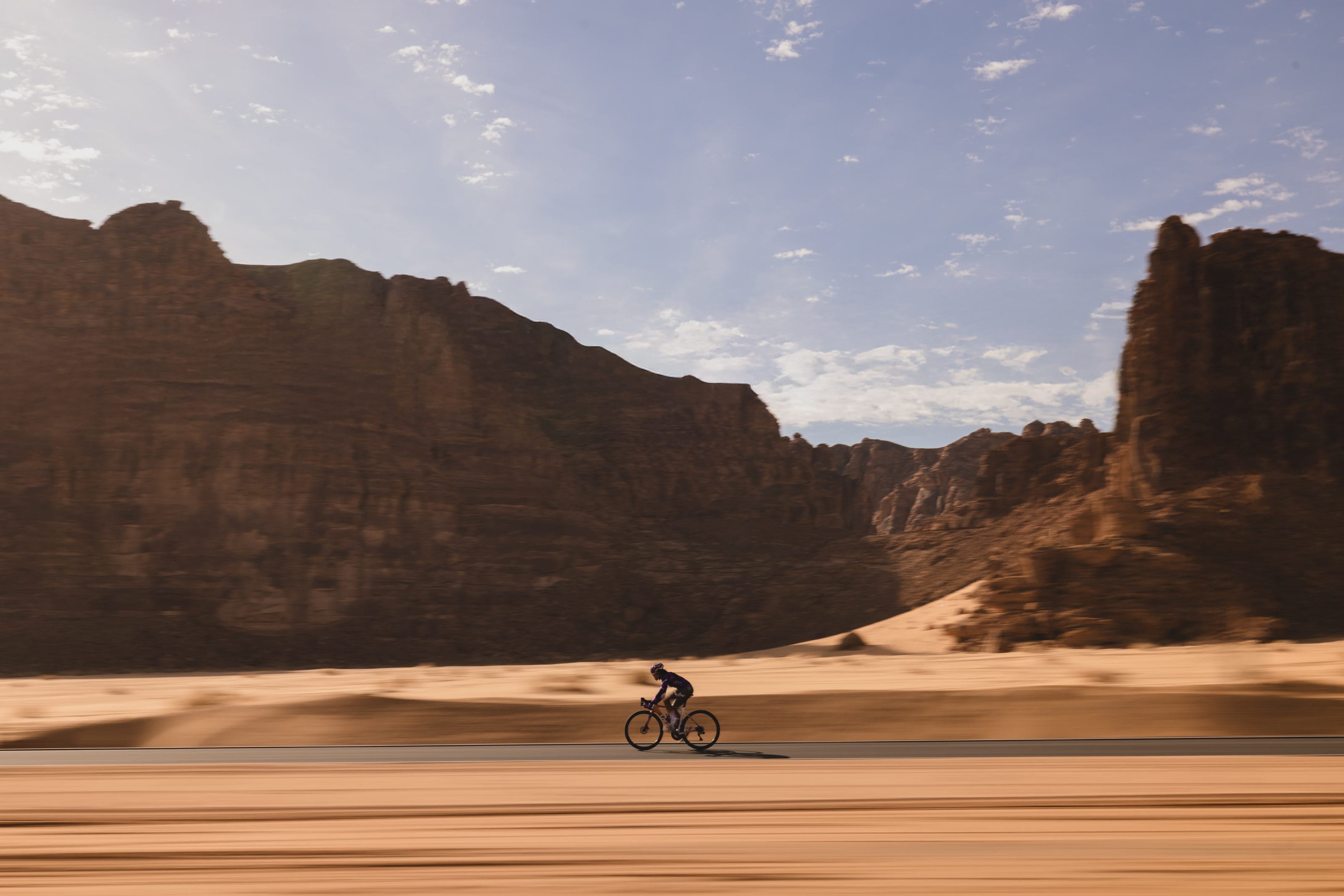 Moroj Adil riding beneath the sandstone cliffs of AlUla