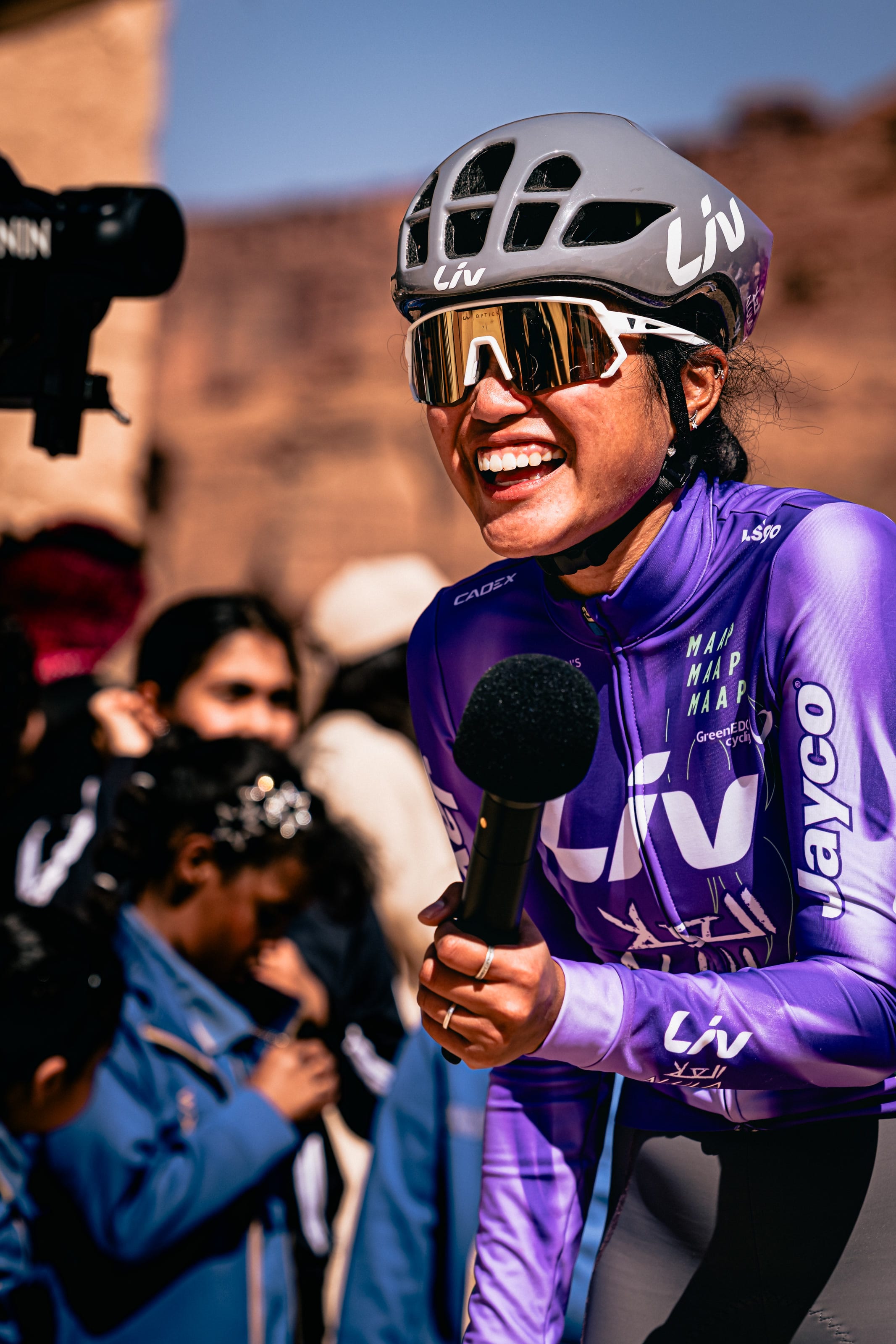 Moroj Adil in Liv AlUla Jayco team kit at a race, smiling during an interview
